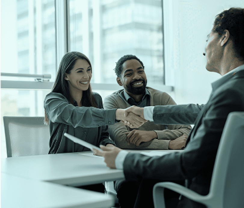 Handshake between three smiling businesspeople in meeting.