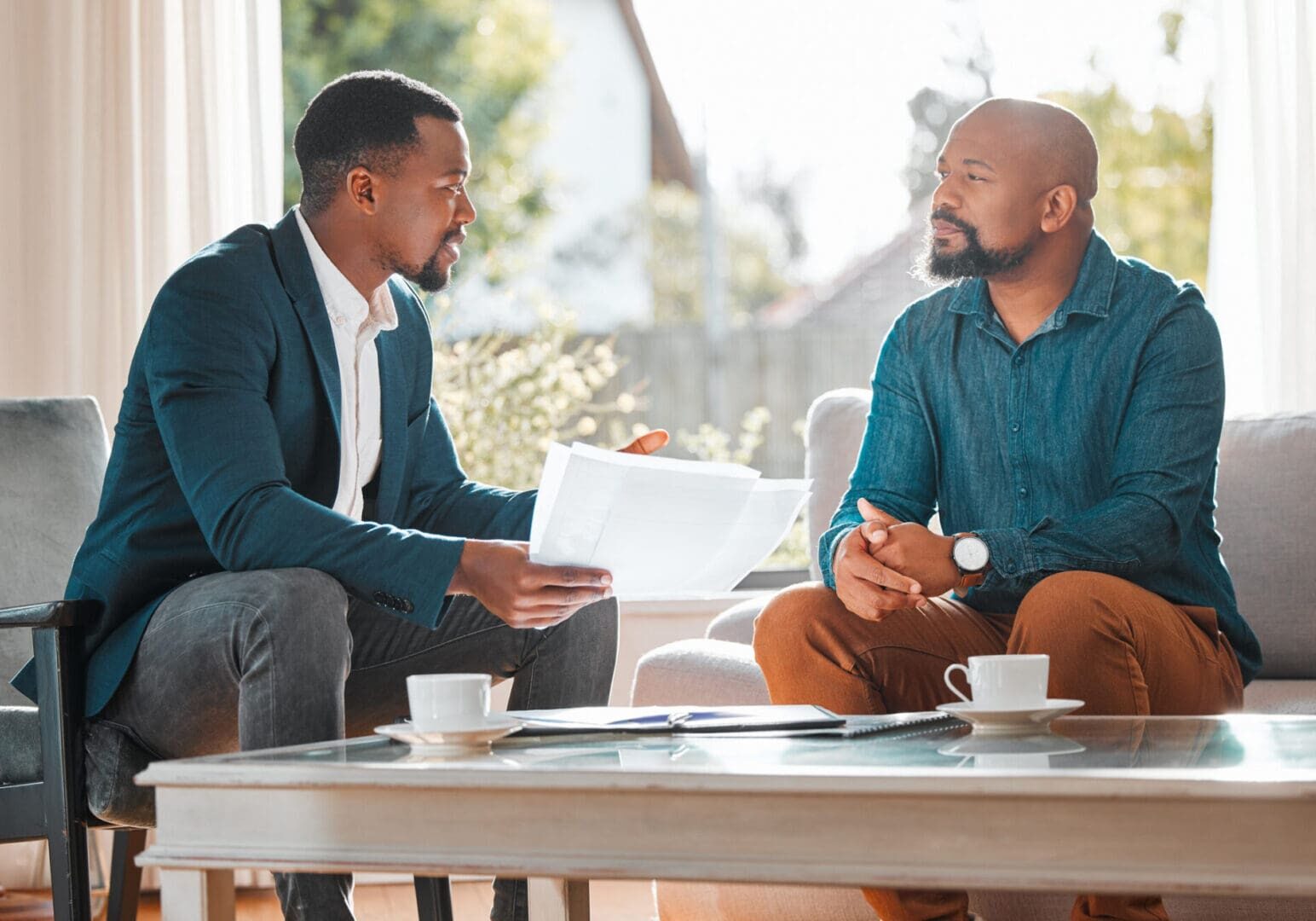 Two men sitting and discussing documents.