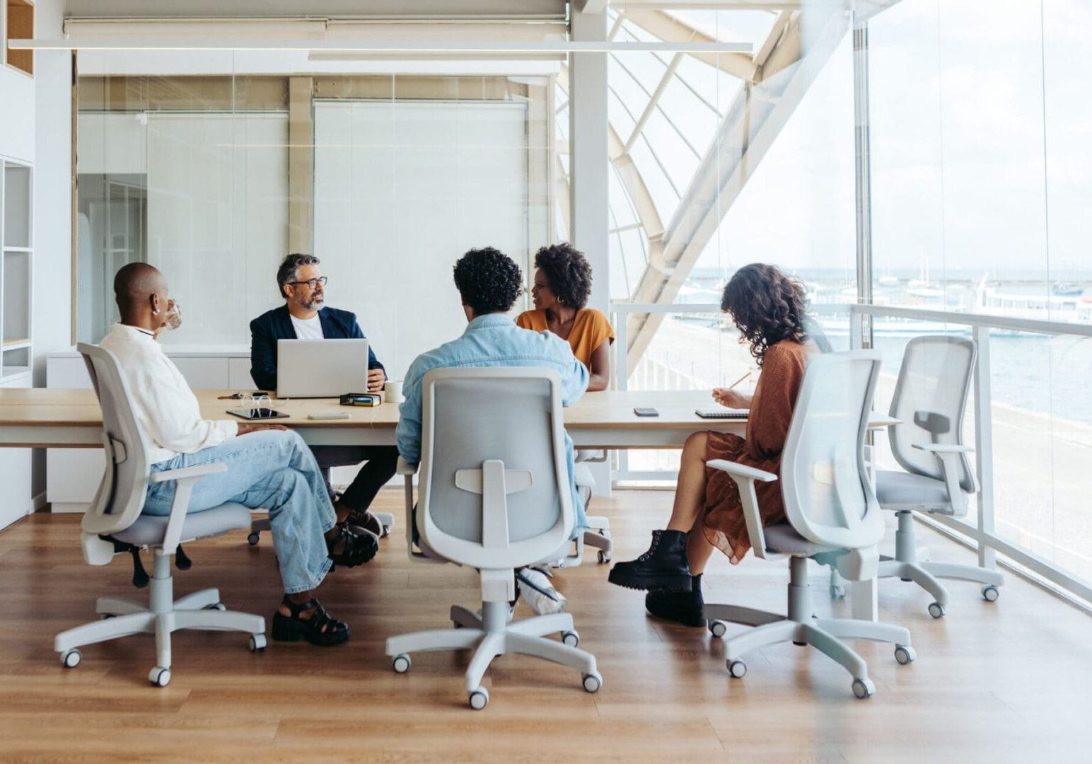 People in a meeting room with laptops.