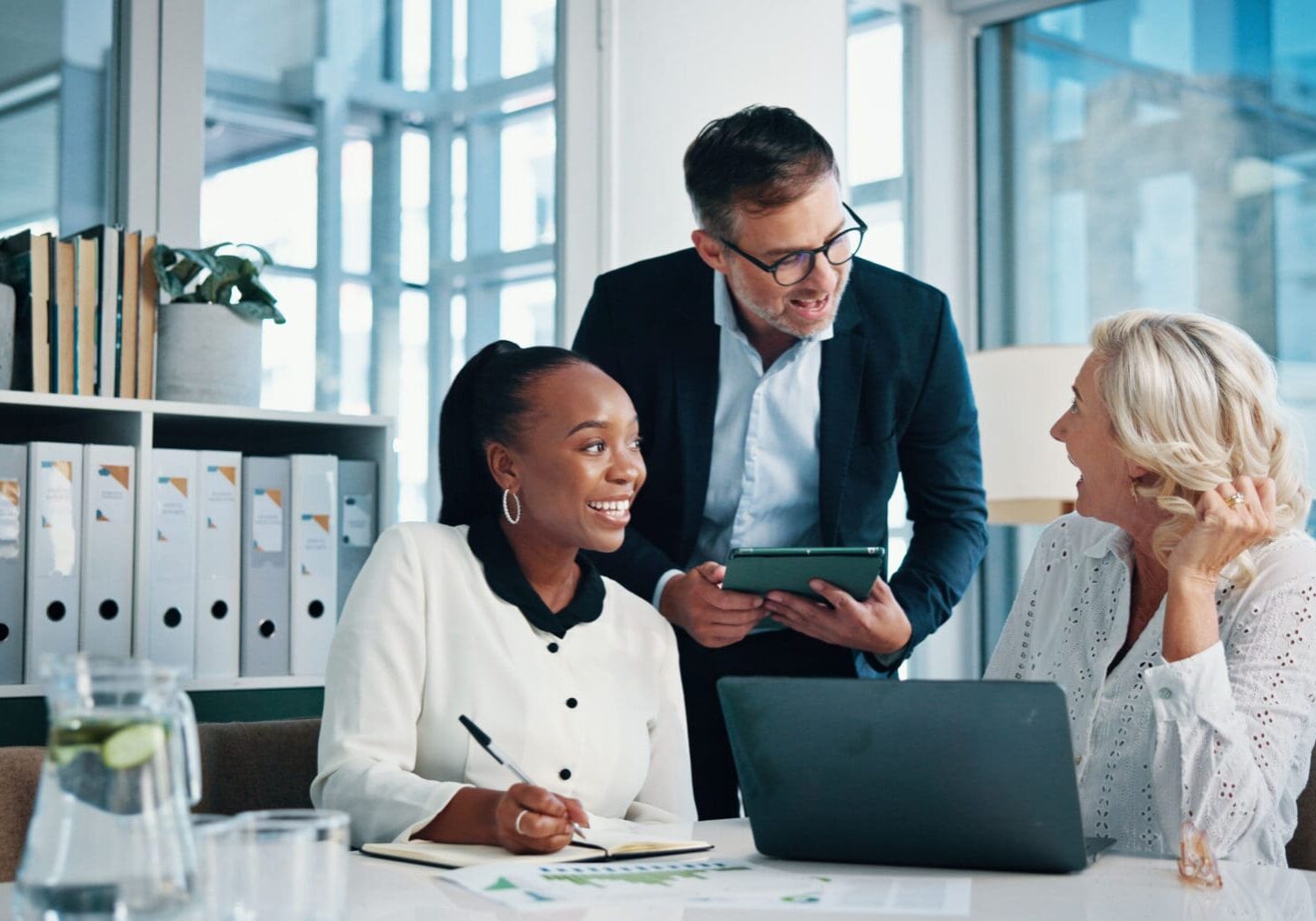 Three colleagues collaborating in a modern office.