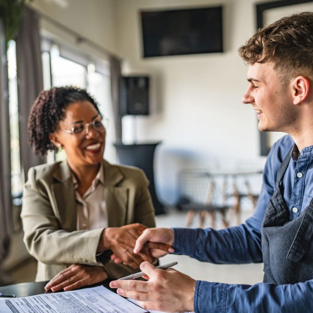 Business meeting handshake in a bright office.